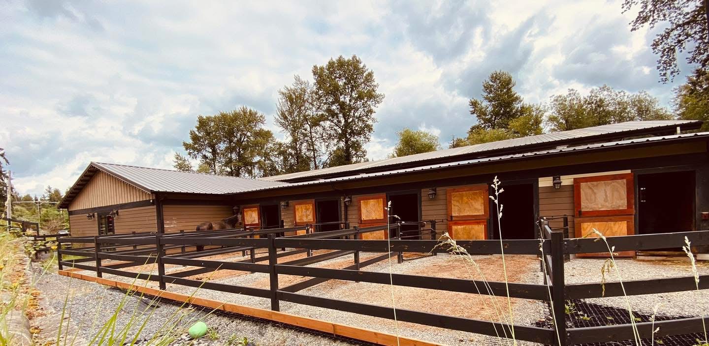 Exterior paddock stall barn with black fencing at Off Broadway Farm